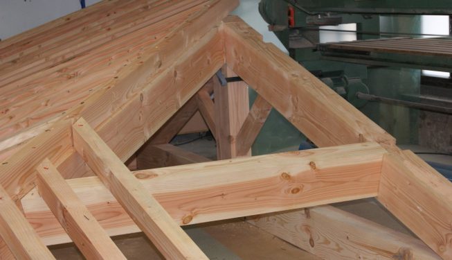 Morceau de charpente rabotée avec tuiles apparentes dans l'atelier
