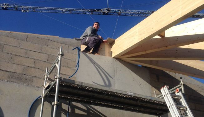 Montage de charpentes dix pentes avec ouvrier accroupi