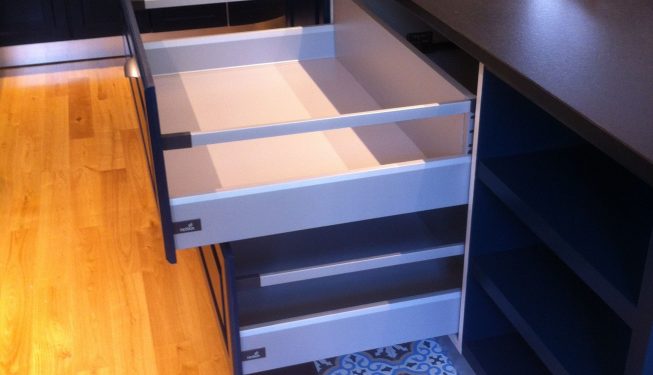 Table et tiroirs ouverts de cuisine menuisée bleue